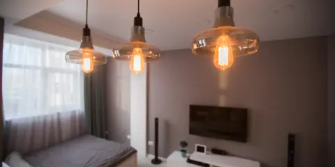 Trzy lampy wiszące z żarówkami Edisona tworzą przytulne oświetlenie bez prądu, idealne do sypialni.