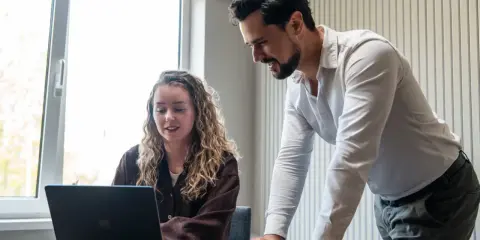 Man en vrouw kijken samen naar een laptop, ter voorbereiding op een gesprek met HR.