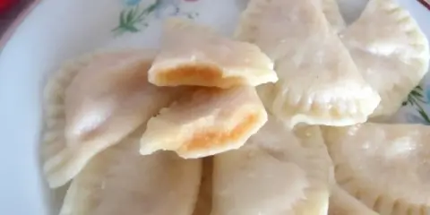 Pyszne pierogi z jabłkami, jeden rozkrojony ukazuje słodkie nadzienie.