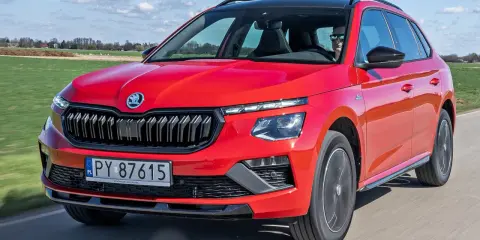 Czerwona Skoda Kamiq w ruchu, idealna na wakacyjne wyjazdy. Sprawdź atrakcyjną skoda kamiq cena.