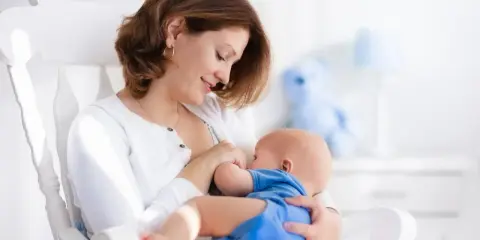 Mama karmi piersią dziecko na bujanym fotelu. Czy to powód, dlaczego dziecko ulewa?