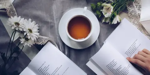 Kawa i kwiaty obok otwartej książki z tekstami po angielsku A1.