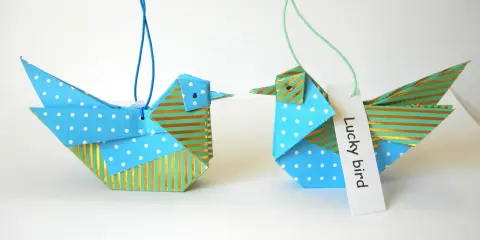 Zwei Origami-Vögel, die zum **Vogel Mobile basteln** einladen. Einer mit Punkten, der andere mit Streifen.