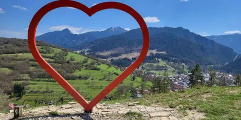 Czerwone serce na tle górskiej panoramy Słowacji. Widok z wieży widokowej na malowniczą dolinę i miasteczko.