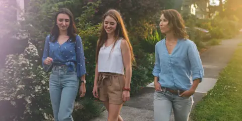Trois femmes profitent d'une promenade paisible, savourant le moment présent. Une scène de slow tech, où la connexion humaine prime sur le numérique.