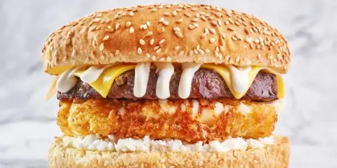 Pyszny burger drwala przepis: soczysty kotlet, chrupiące panierowane jajko, ser i biały sos na sezamowej bułce.