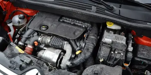 Silnik 1.6 HDI w samochodzie, widoczne elementy układu dolotowego, turbosprężarka i skrzynka bezpieczników.