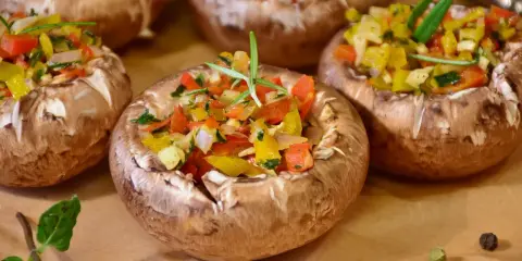 Champignons farcis aux poivrons colorés et herbes fraîches, prêts à être dégustés.