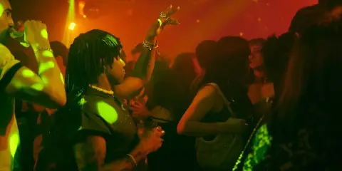 Persone che ballano in un locale notturno, luci stroboscopiche e musica alta: il vero clubbing significato.