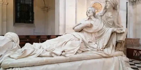 Pomnik kardynała Richelieu. Ciekawostki o jego życiu i wpływach. Rzeźba przedstawia go w otoczeniu alegorycznych postaci.