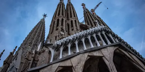 La Sagrada Familia, un espectáculo de arquitectura gótica y moderna, con grúas que sugieren su construcción continua. Un antes y después de una obra maestra.