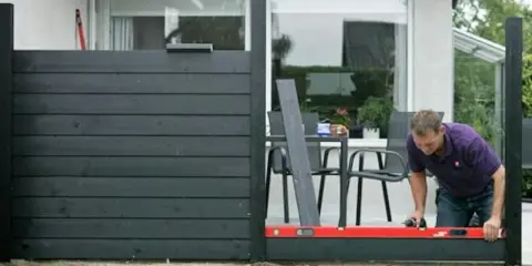 Man bygger ett modernt vindskydd till altanen. Inspiration för ditt eget utomhusprojekt.