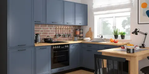Nowoczesna kuchnia z niebieskimi frontami szafek, ceglanym detalem na ścianie i drewnianym blatem.