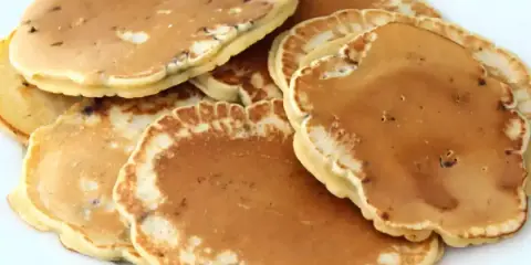 Pile de pancakes dorés aux pépites de chocolat, parfaits pour une recette gourmande.
