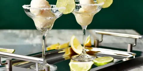 Dwa kieliszki z sorbetem cytrynowym, udekorowane solą i limonką. Idealny sposób, jak podawać tequilę w upalny dzień.