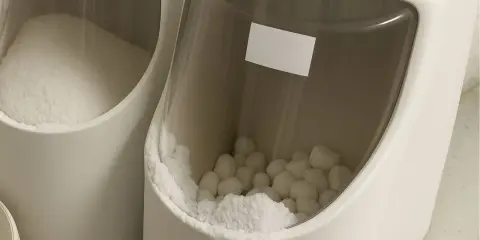 Deux bacs d'adoucisseur d'eau. L'un contient du sel en poudre, l'autre des pastilles de sel. L'eau dans le bac à sel adoucisseur est essentielle.