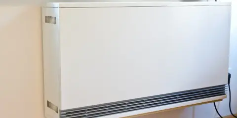 Ein weißer Nachtspeicherheizkörper an einer Wand. Der Austausch von Nachtspeicherheizungen ist Pflicht, um Energie zu sparen.