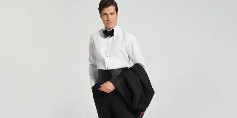 Mann im Smoking mit Fliege und Kummerbund, bereit für den black tie dresscode herren.