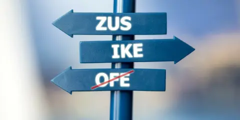 Znak drogowy z napisami ZUS, IKE i przekreślonym OFE. Czy można wypłacić pieniądze z IKE przed emeryturą?