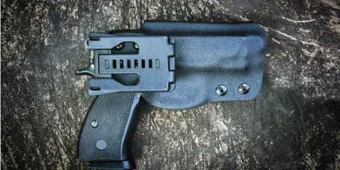 Czarna kabura wewnętrzna na broń, dyskretnie ukrywająca pistolet.