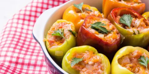 Poivrons colorés farcis de riz et de légumes, garnis de persil frais. Un plat savoureux de légumes farcis.