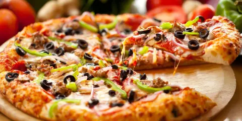 Gotowy spód do pizzy, z ciągnącym się serem, oliwkami, papryką i mięsem, aż chce się go włożyć do pieca!