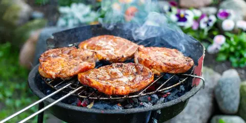 Saftige Steaks brutzeln auf dem Grill. Das Aroma von gegrilltem Fleisch liegt in der Luft.