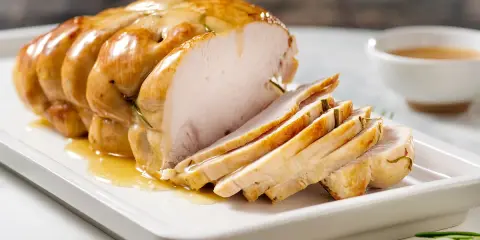 Succulento arrosto di tacchino affettato, bagnato nel suo sugo dorato, pronto per essere gustato.