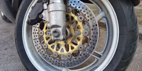 Motocykl z tarczami hamulcowymi i zaciskiem. Ostre koło hamowanie zapewnia bezpieczeństwo na drodze.