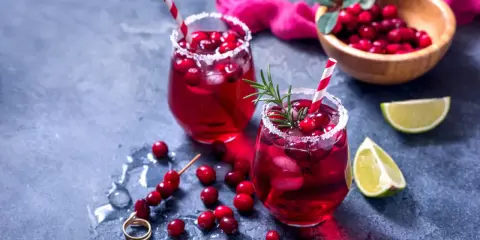 Orzeźwiający drink bezalkoholowy z grenadiną, lodem i żurawiną, udekorowany rozmarynem. Idealny na letnie popołudnie.