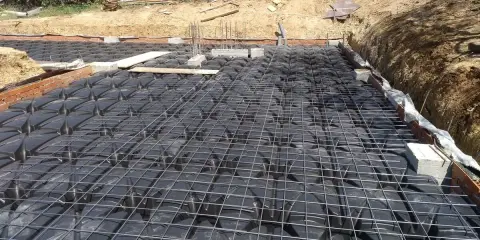 Preparación para un forjado sanitario ventilado: se aprecian los casetones negros y la malla metálica sobre ellos.