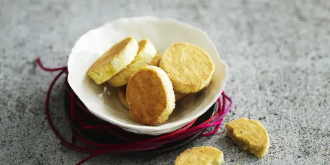 Délicieux sablés moelleux dorés, servis dans une coupelle blanche. Parfaits pour accompagner un café.