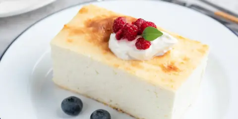 Puszysty sernik z malinami i bitą śmietaną. Idealny jaki aromat do sernika? Waniliowy lub cytrynowy.