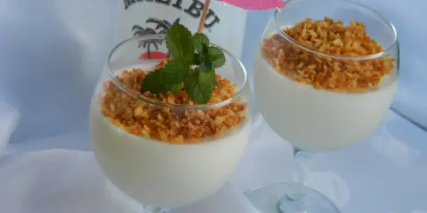 Dwa pucharki z deserem na bazie **malibu z mlekiem zagęszczonym**, posypane wiórkami kokosowymi i ozdobione miętą.