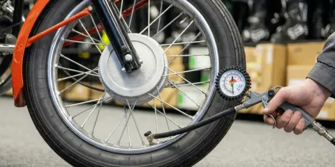 Sprawdzanie ciśnienia w oponach motocykla. Manometr pokazuje aktualne wartości, pomocny przy odczycie z tabeli ciśnienia w oponach.