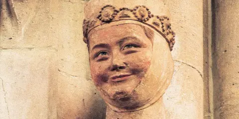 Kamienna rzeźba bł. Salomei z uśmiechniętą twarzą i ozdobną koroną.