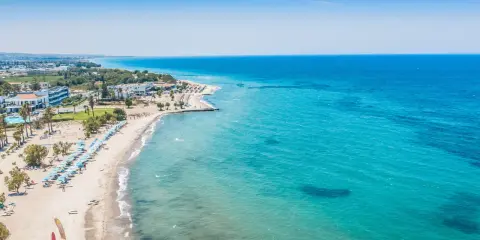 Piękna plaża na wyspie Kos z turkusową wodą, leżakami i palmami. Idealne miejsce na wakacje.