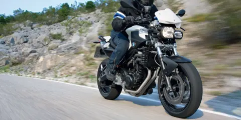 Motocyklista w kasku jedzie na BMW F800R po krętej drodze. Poznaj jego dane techniczne.