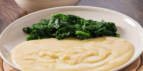 Piatto con purè di fave cremoso e spinaci saltati. Un contorno semplice e gustoso.