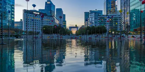 Reflejos de edificios modernos y el youfirst grande arche en un estanque.
