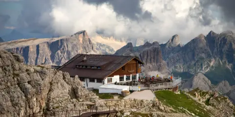 Rifugio alpino in Alto Adige, con sentiero metallico e imponenti vette sullo sfondo.
