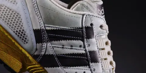 Detailaufnahme des Adidas ZX 8000 Release. Der Schuh zeigt die charakteristischen Streifen und eine goldene Sohle.