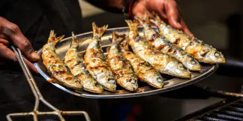 Une assiette de sardines grillées, dorées et savoureuses, prêtes à être dégustées.