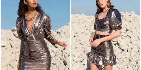 Dwie kobiety w metalicznych kreacjach w stylu y2k. Jedna w dopasowanej sukience z dekoltem V i szerokim paskiem, druga w crop topie i spódniczce mini z falbanką.