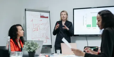 Zespół omawia strategię rozwoju, w tym automatyzację testów oprogramowania. Na tablicy widać KPI, NPS, CSI i SLA.