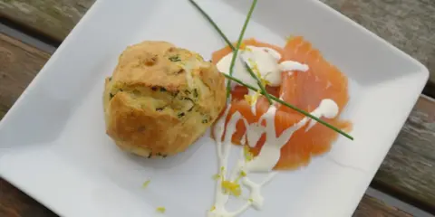 Matiga muffins med örter serveras med gravad lax, en klick gräddfil och citronzest.