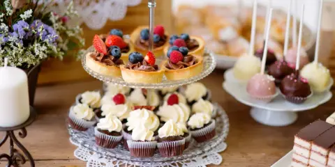 Słodkie przekąski na imprezę: babeczki, tartaletki z owocami, cake pops i ciasto.