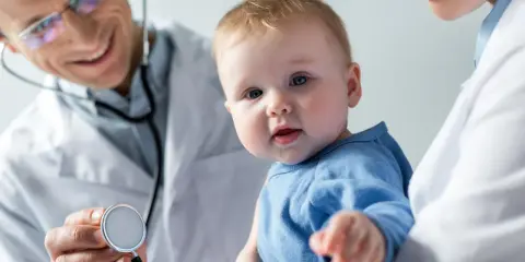 Lekarz bada niemowlaka. Wodniak jądra u niemowlaka co robić? Konsultacja lekarska.