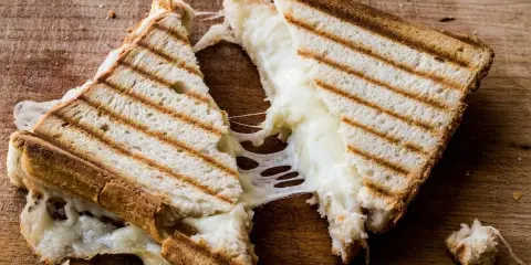 Pyszny, ciągnący się ser w tostach. Zastanawiasz się, ile kcal ma tost z serem? Ten wygląda na około 300-400 kcal.