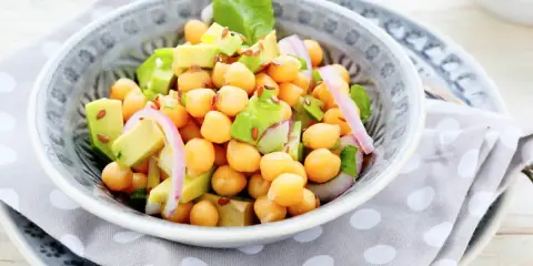 Deliciosa ensalada de garbanzos y aguacate, con cebolla morada y semillas de lino. Fresca y nutritiva.